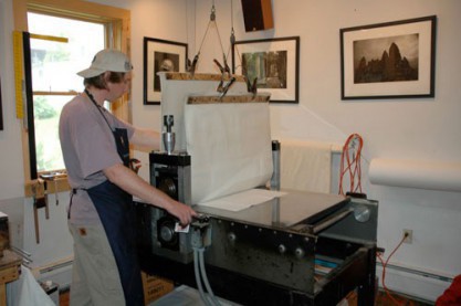 The plate and paper are run through the press.
